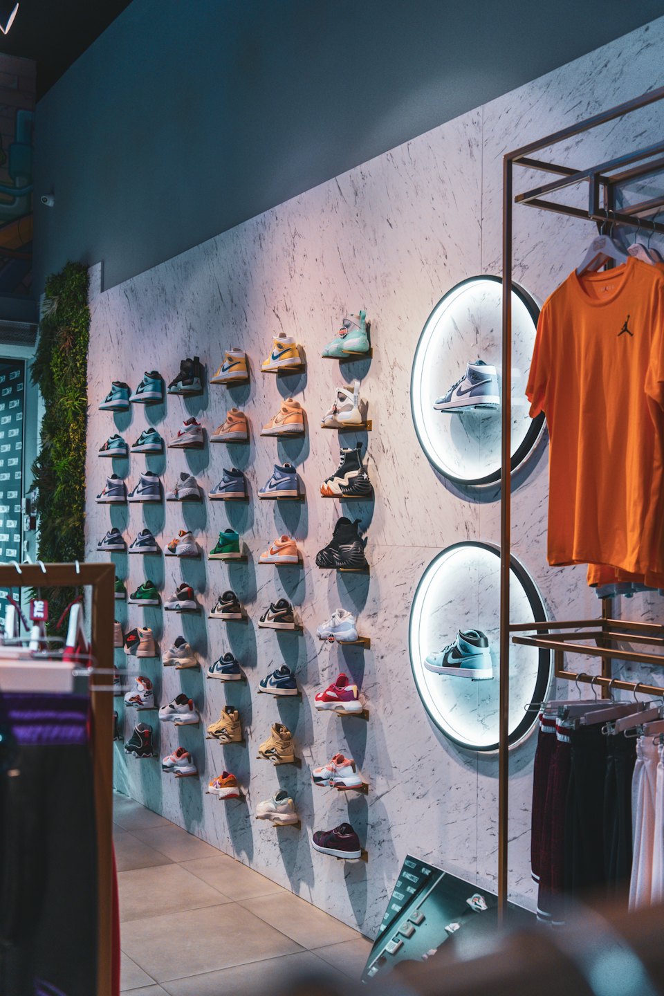 Modern store wall displaying numerous sneakers on shelves.